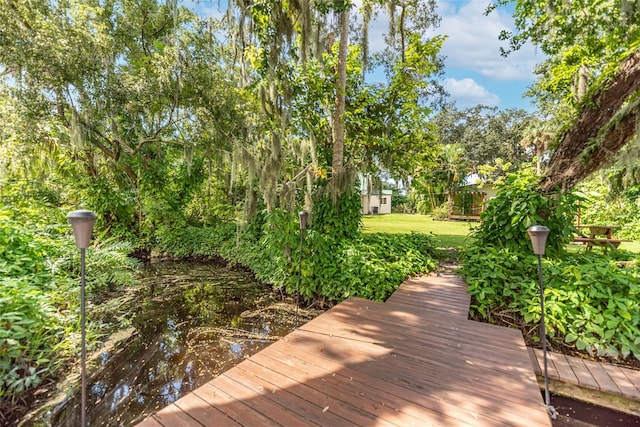 view of home's community with a lawn and a water view