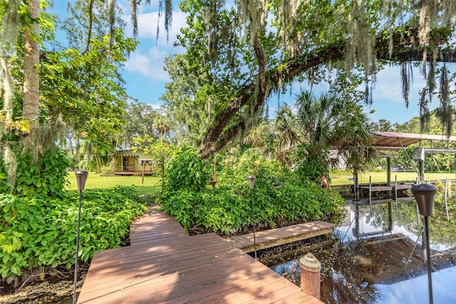 dock area with a water view and a yard