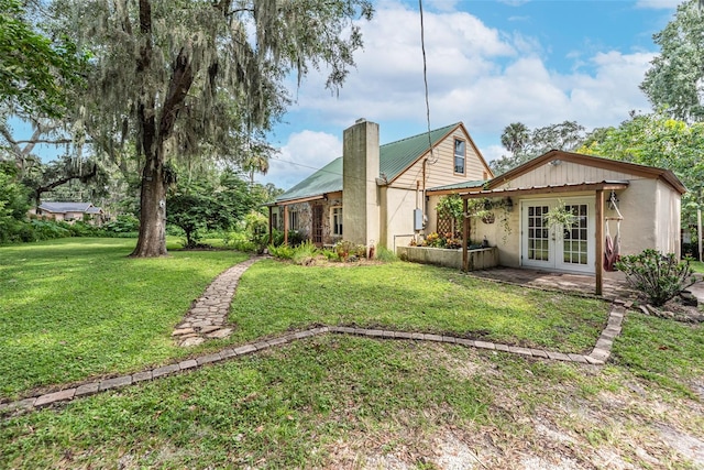 back of property featuring french doors and a yard