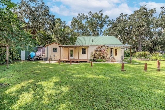 rear view of property featuring covered porch and a yard