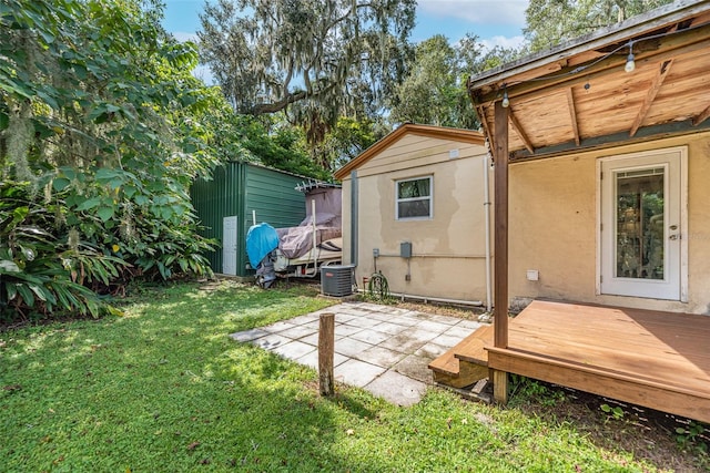 exterior space with cooling unit, a deck, and a patio area