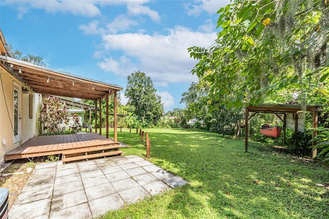 view of yard featuring a patio and a wooden deck