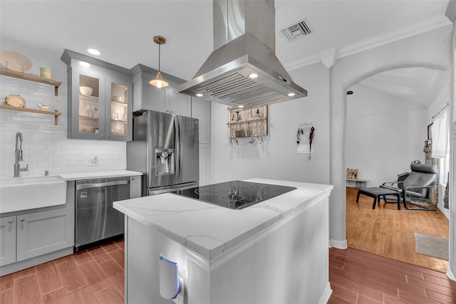 kitchen with light stone counters, dark hardwood / wood-style floors, sink, island exhaust hood, and stainless steel appliances