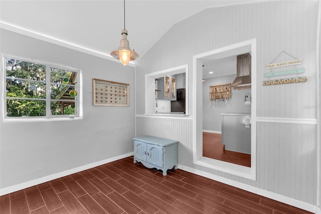 unfurnished room featuring lofted ceiling, wood walls, and dark hardwood / wood-style floors