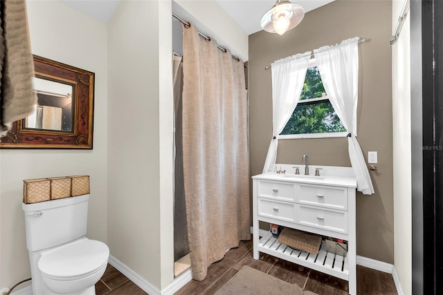 bathroom featuring wood-type flooring, a shower with curtain, vanity, and toilet