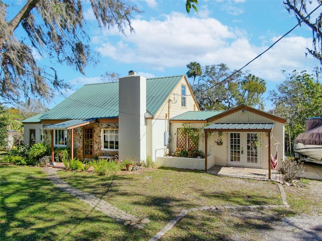 back of house with a lawn and french doors