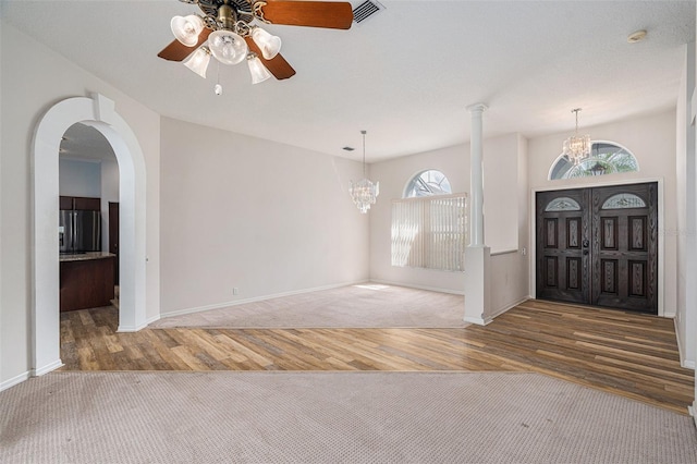 foyer featuring wood-type flooring and ceiling fan with notable chandelier