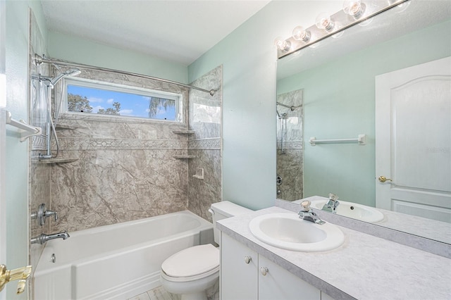 full bathroom featuring tiled shower / bath, vanity, and toilet