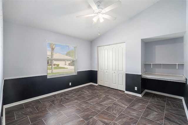 unfurnished bedroom featuring ceiling fan, lofted ceiling, and a closet