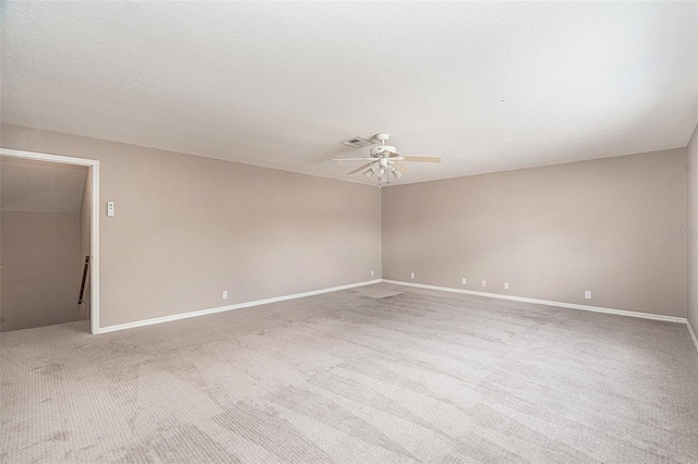 empty room featuring light colored carpet, a textured ceiling, and ceiling fan