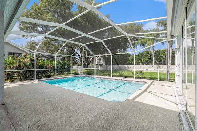 view of swimming pool with glass enclosure and a patio