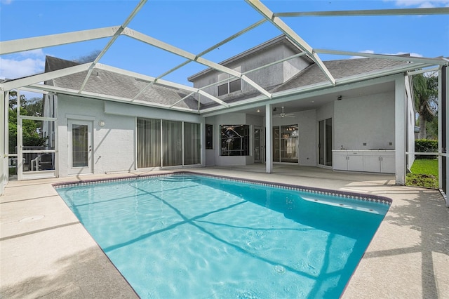 back of house with glass enclosure, ceiling fan, and a patio area