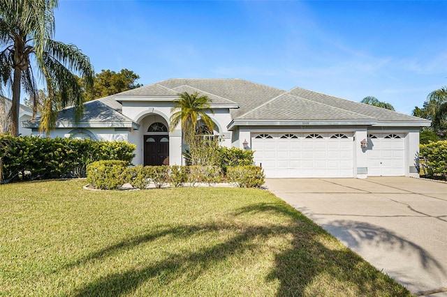 single story home featuring a garage and a front yard