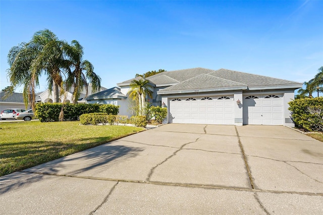 ranch-style house featuring a garage and a front lawn