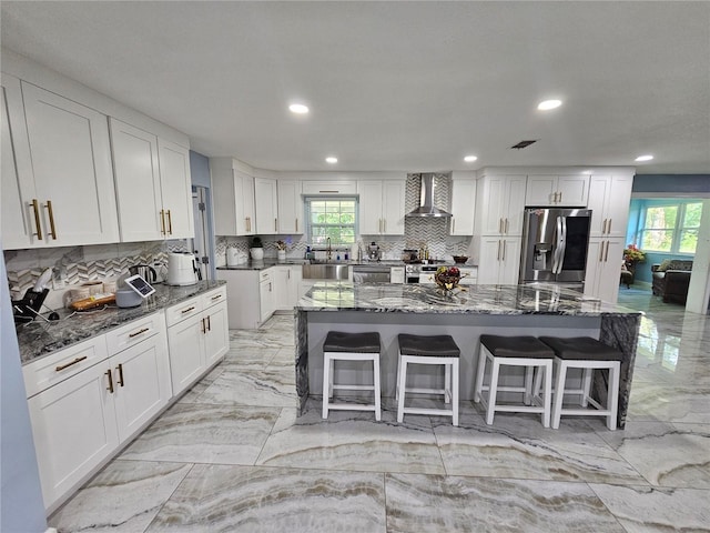 4810 N Galloway Rd, Lakeland, FL 33810 - kitchen with appliances with stainless steel finishes, light marble finish floors, wall chimney range hood, recessed lighting, and decorative backsplash