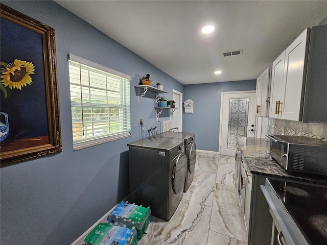 4810 N Galloway Rd, Lakeland, FL 33810 - kitchen with independent washer and dryer, light marble finish flooring, white cabinets, dark stone countertops, and recessed lighting