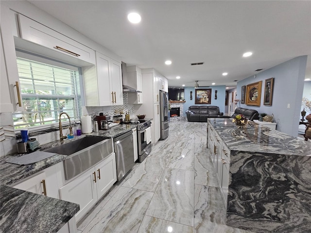 4810 N Galloway Rd, Lakeland, FL 33810 - kitchen featuring stainless steel appliances, open floor plan, dark stone countertops, recessed lighting, and white cabinetry