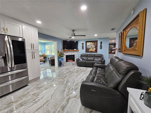 4810 N Galloway Rd, Lakeland, FL 33810 - living room featuring ceiling fan, light marble finish flooring, a fireplace, recessed lighting, and a textured ceiling