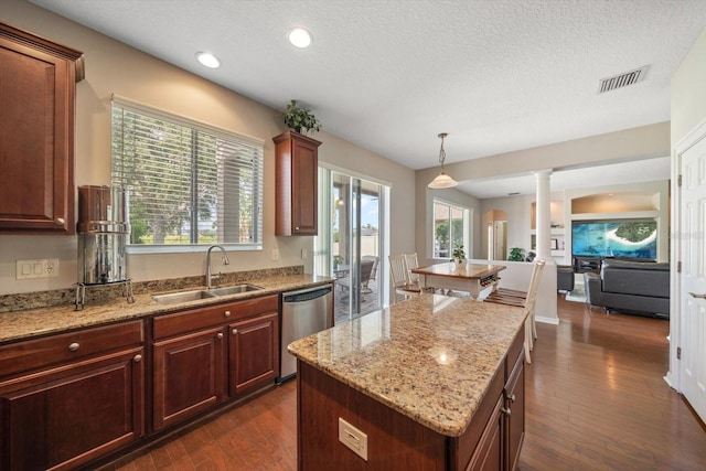 kitchen with dark hardwood / wood-style floors, a center island, sink, and stainless steel dishwasher