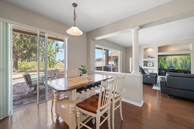 dining area with dark hardwood / wood-style floors, decorative columns, and a healthy amount of sunlight