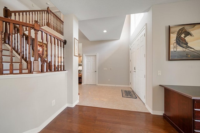 corridor with lofted ceiling and hardwood / wood-style floors