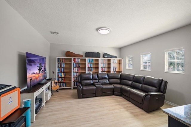 living room featuring a textured ceiling and light hardwood / wood-style flooring