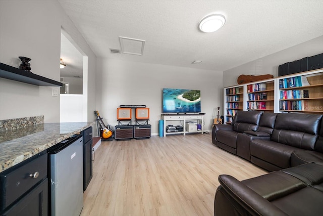 living room featuring a textured ceiling and light wood-type flooring