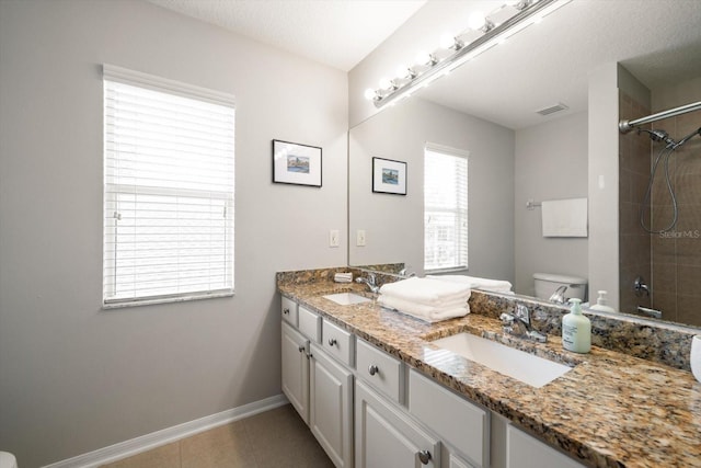 bathroom featuring a tile shower, tile patterned flooring, a textured ceiling, vanity, and toilet