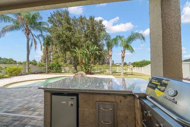 view of patio with a swimming pool and a grill