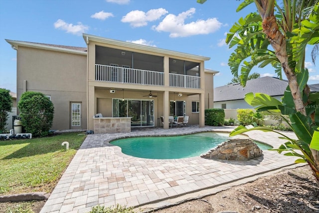 view of pool with ceiling fan, a sunroom, a lawn, and a patio area