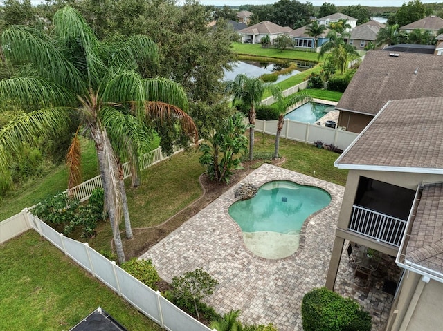 view of swimming pool with a patio, a water view, and a yard