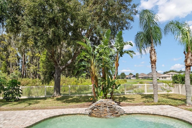 view of pool with a lawn