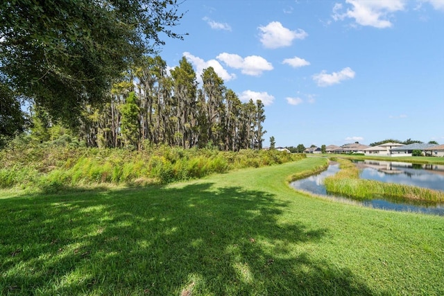 view of community with a lawn and a water view