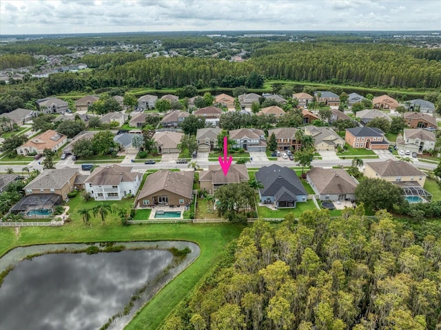 drone / aerial view with a residential view, a water view, and a wooded view