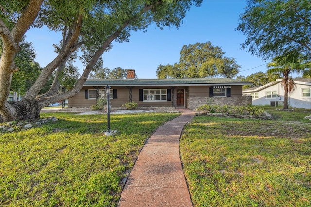 1756 Ashton Abbey Rd, Clearwater, FL 33755 - ranch-style home featuring stone siding, a chimney, and a front yard