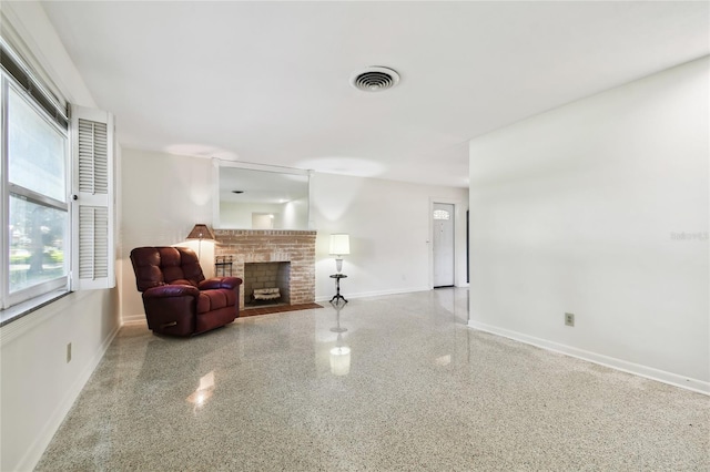 1756 Ashton Abbey Rd, Clearwater, FL 33755 - living room featuring speckled floor, baseboards, a fireplace, and visible vents