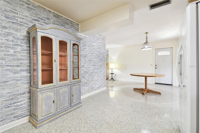 1756 Ashton Abbey Rd, Clearwater, FL 33755 - interior space with visible vents, speckled floor, and brick wall