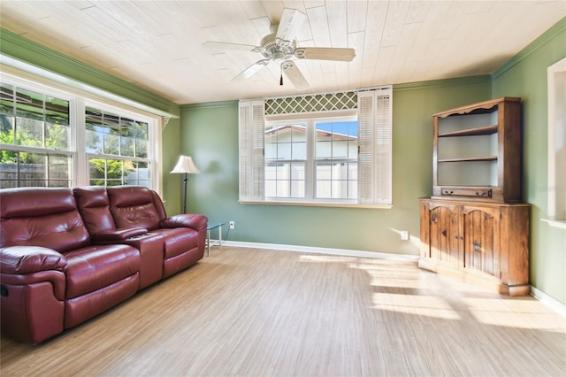 living room featuring crown molding, light hardwood / wood-style floors, ceiling fan, and a wealth of natural light