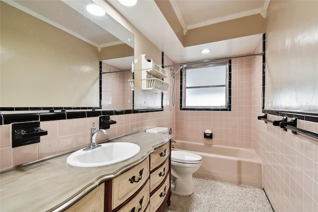 full bathroom with tile walls, tiled shower / bath combo, vanity, and toilet