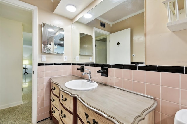 bathroom featuring vanity and tile walls