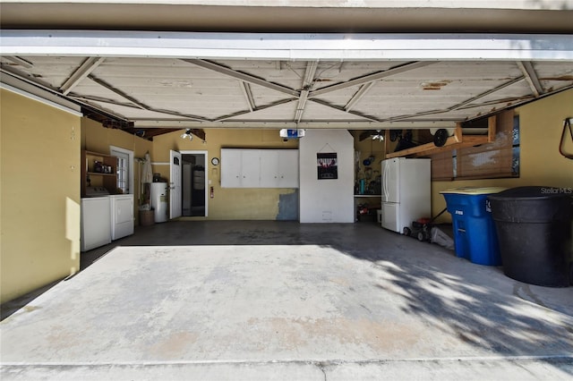 garage featuring a garage door opener, white refrigerator, and washing machine and dryer