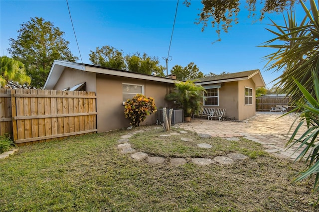 back of property featuring a lawn and a patio area