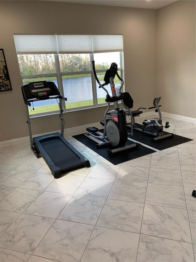 workout room featuring a water view