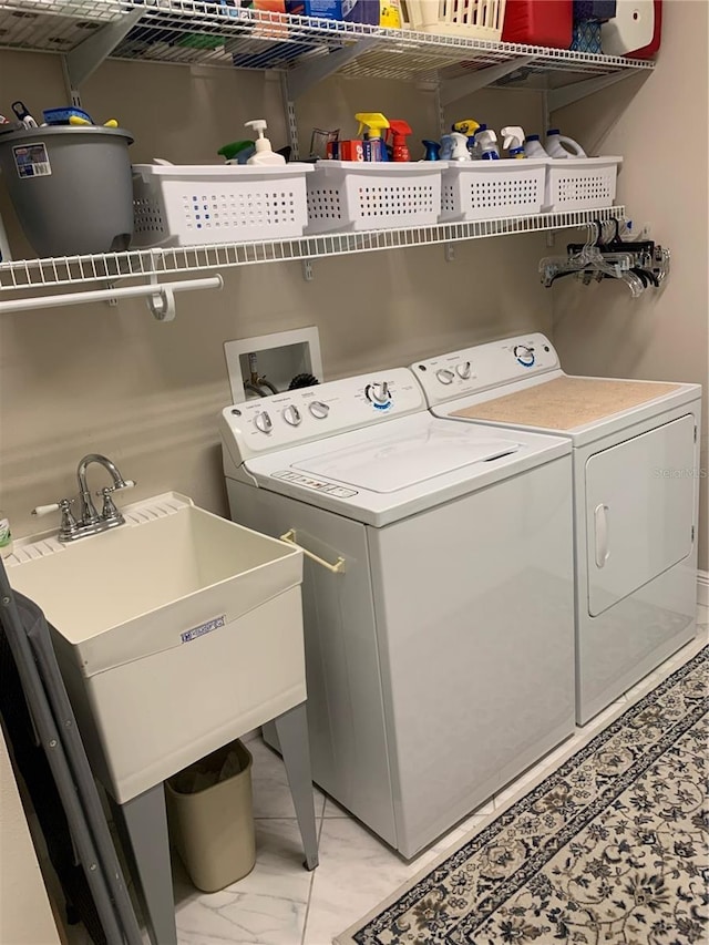 16015 Cape Coral Dr, Wimauma, FL 33598 - laundry room featuring washing machine and dryer and light marble finish flooring