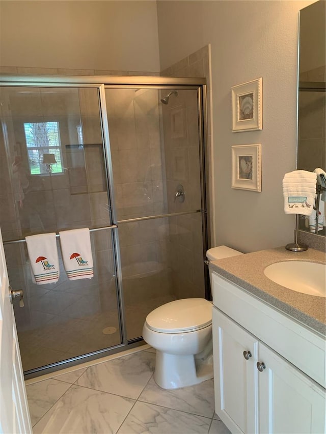 bathroom featuring vanity, an enclosed shower, and toilet