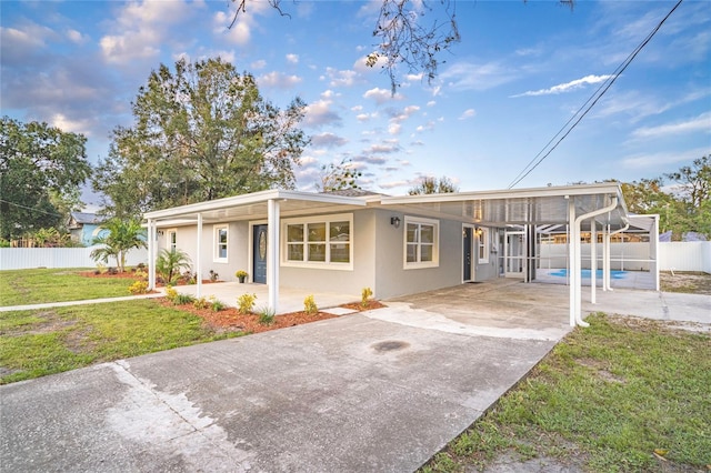 view of front of property featuring a patio, a fenced in pool, and a front lawn