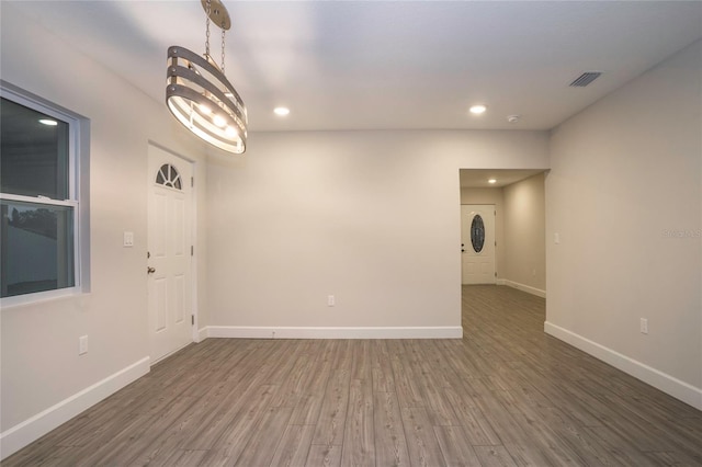 unfurnished room featuring dark wood-type flooring and a chandelier