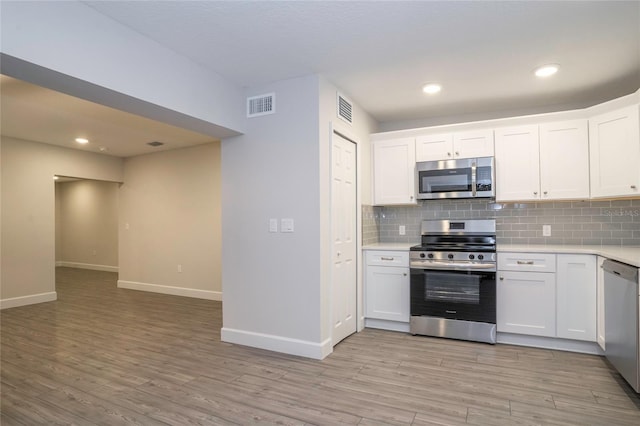 kitchen featuring white cabinets, light hardwood / wood-style flooring, and stainless steel appliances