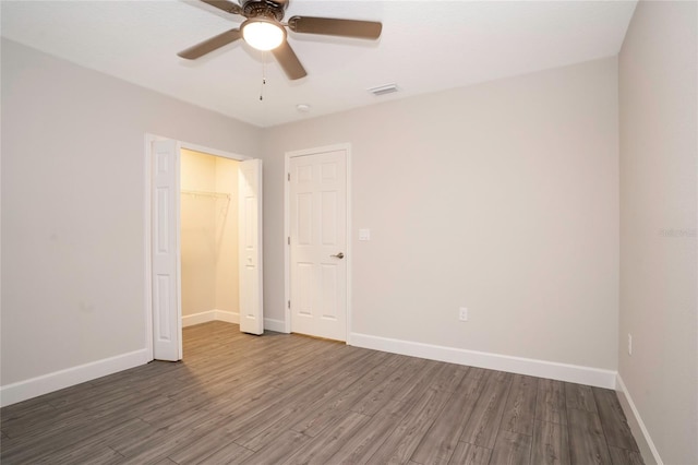 unfurnished room featuring dark hardwood / wood-style floors and ceiling fan