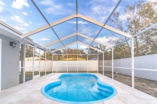 view of pool with a patio area and glass enclosure